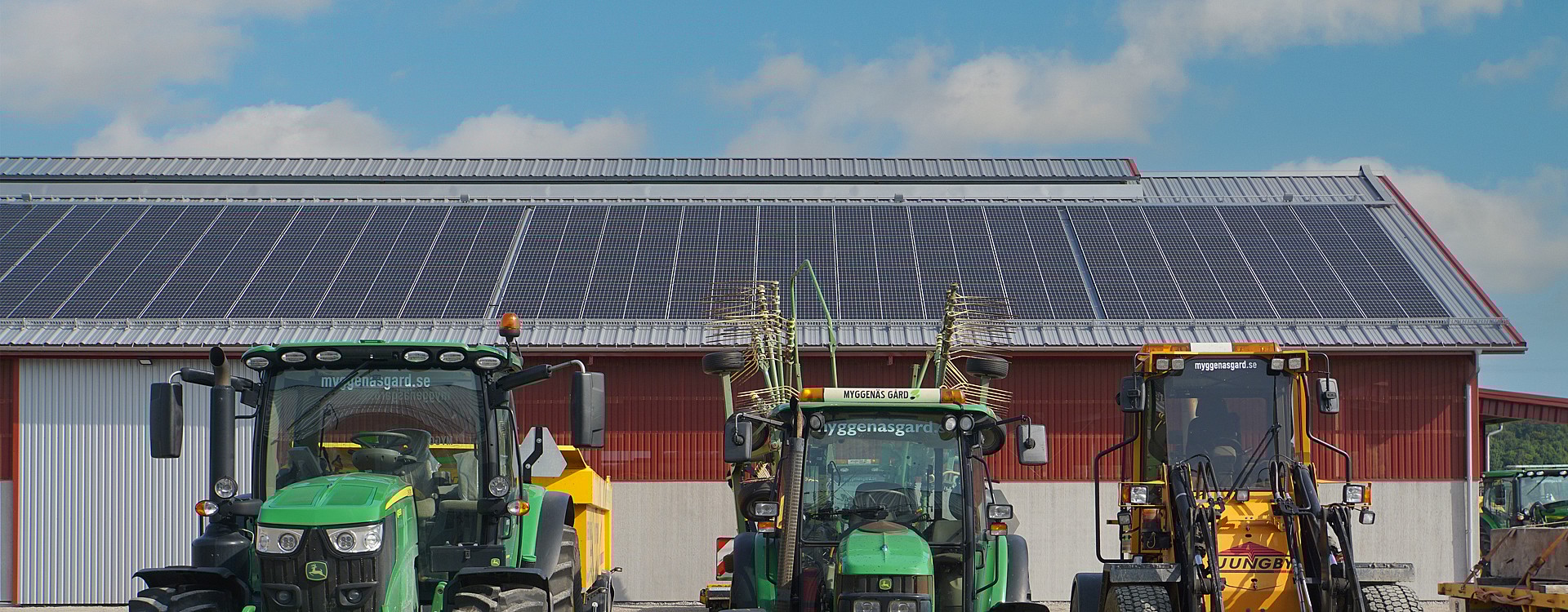 Solceller på lantbrukshall med traktorer i förgrunden